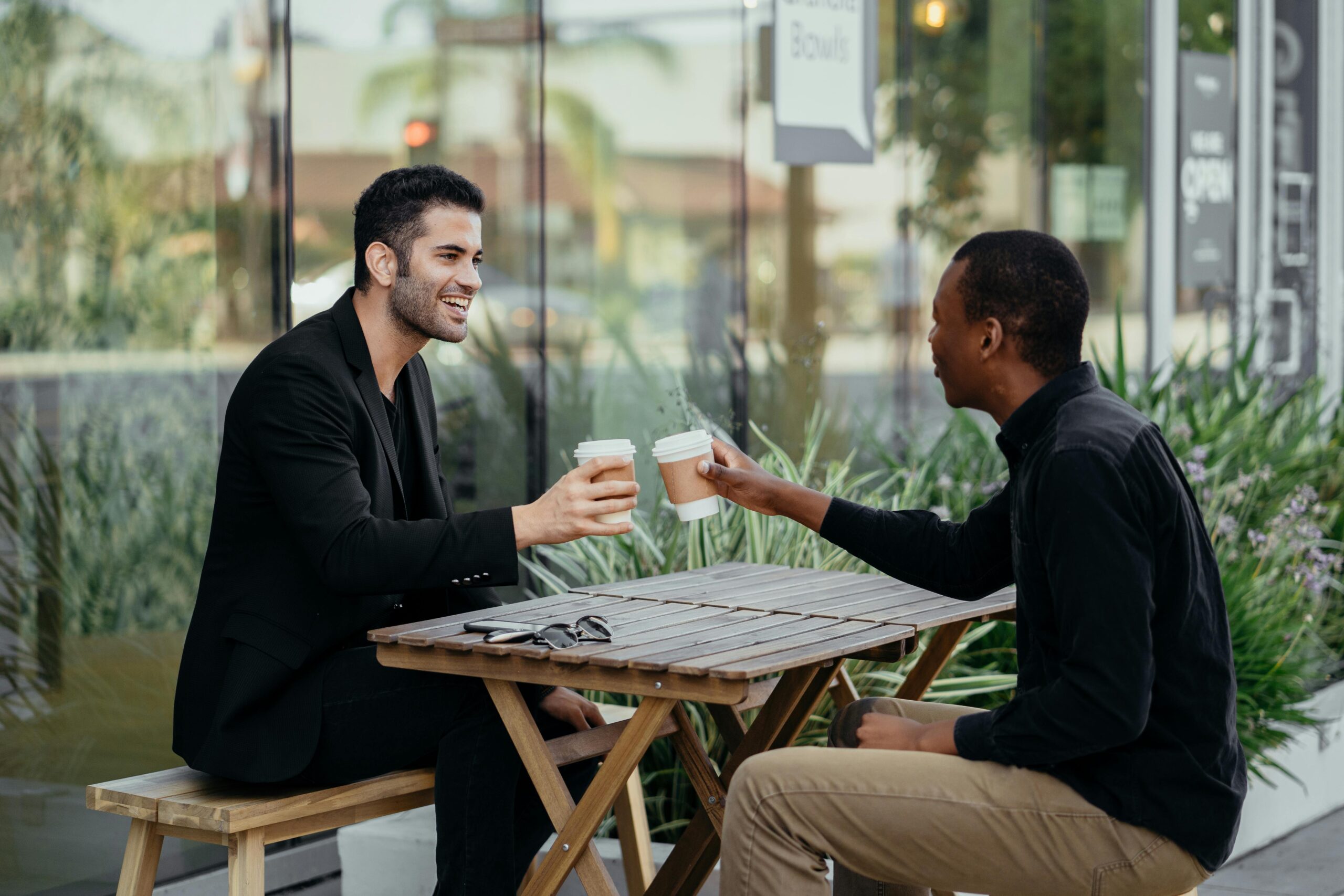 Happy Male Colleagues talking to each other over coffee